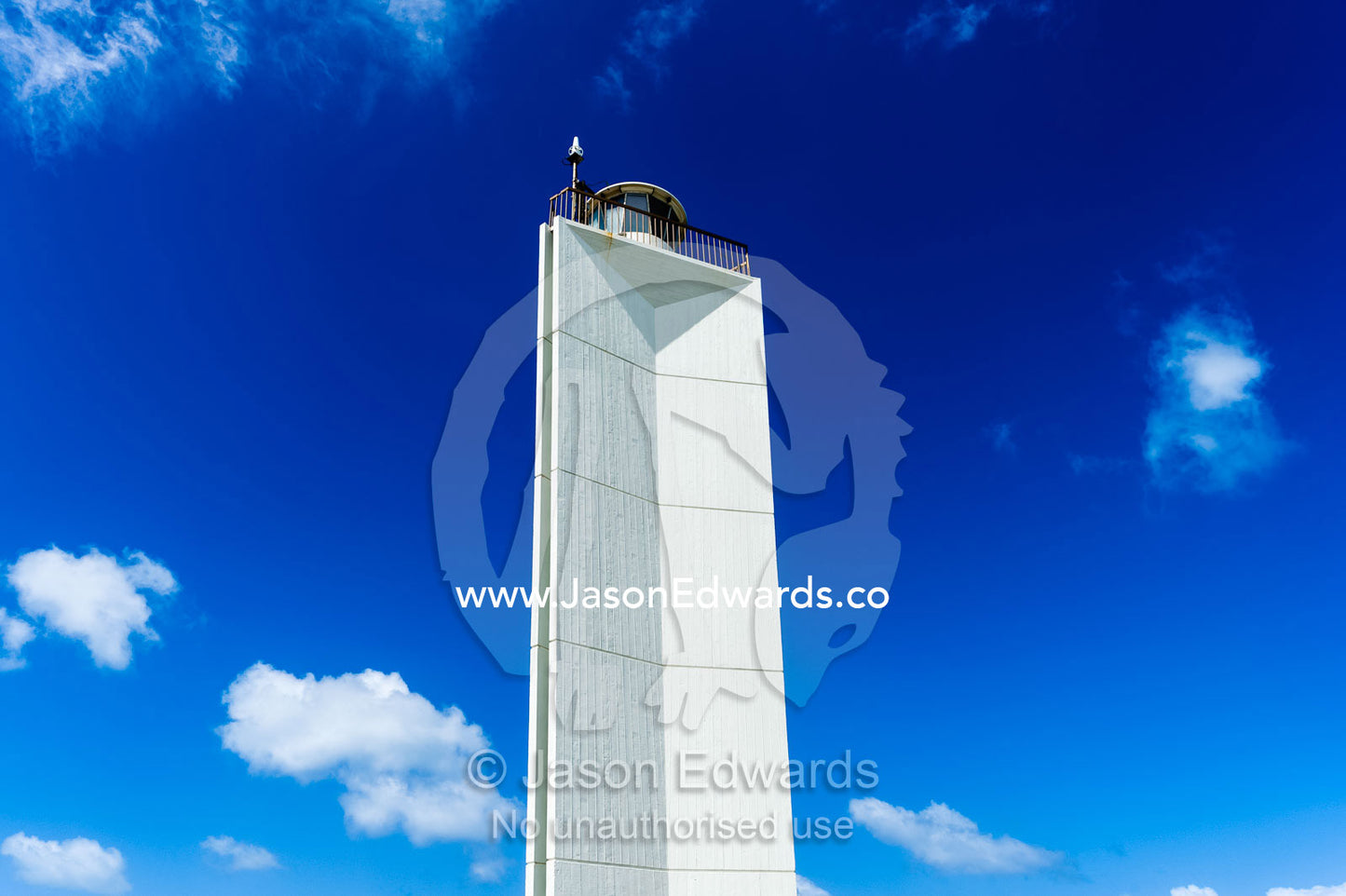 A stark white lighthouse on a rugged limestone coastline. Robe, Limestone Coast, South Australia, Australia.