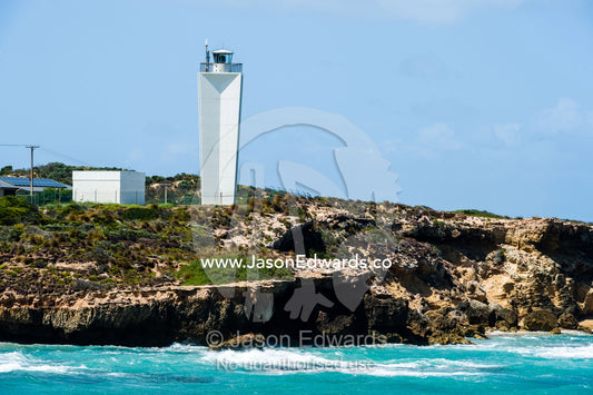 A stark white lighthouse on a rugged limestone coastline. Robe, Limestone Coast, South Australia, Australia.