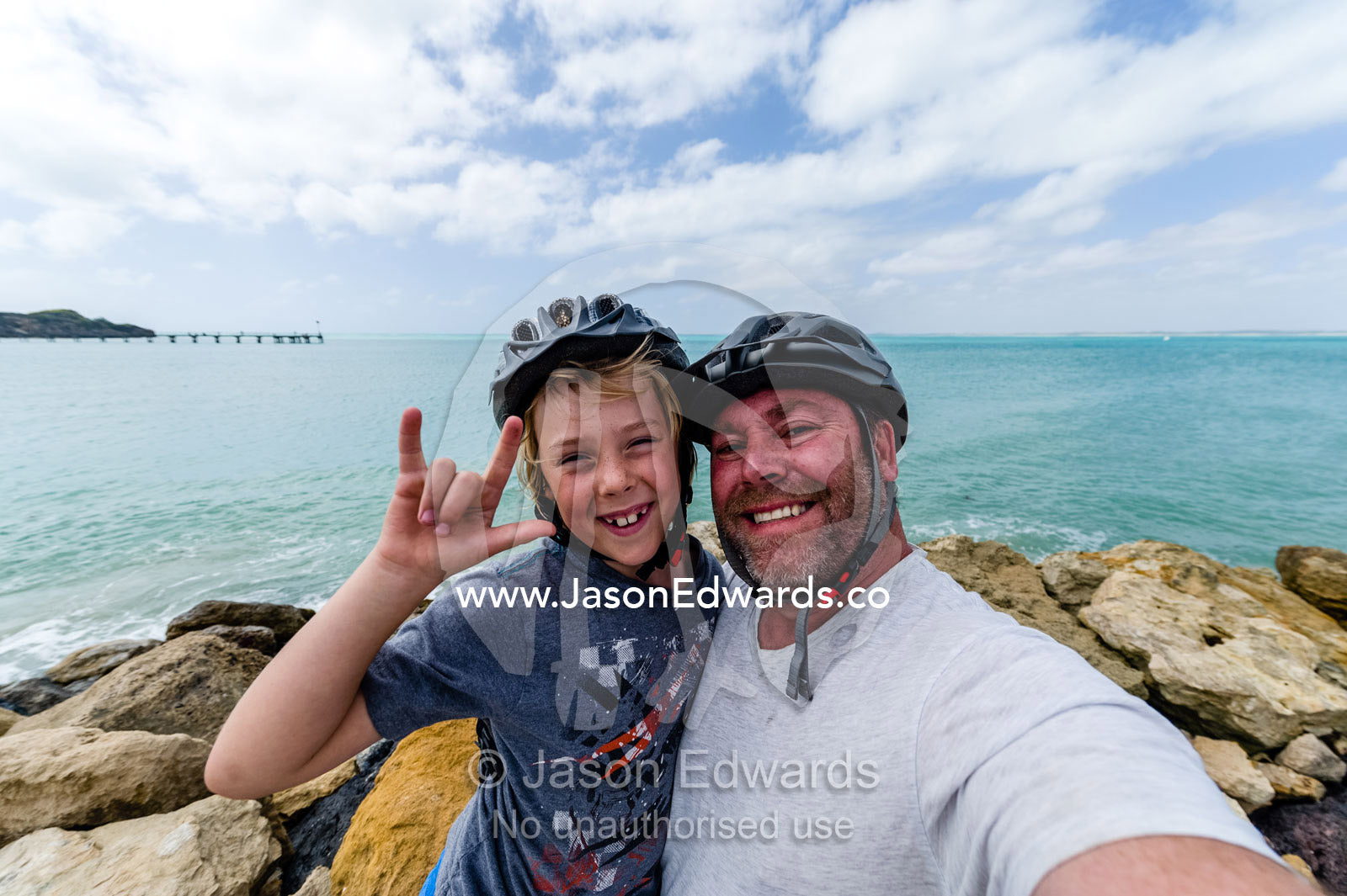 A father and son hugging each other on a bike ride. Robe, Limestone Coast, South Australia, Australia.