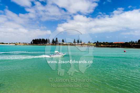 A speed boat crosses the turquoise waters of a safe harbour on a sunny day. Robe, Limestone Coast, South Australia, Australia.