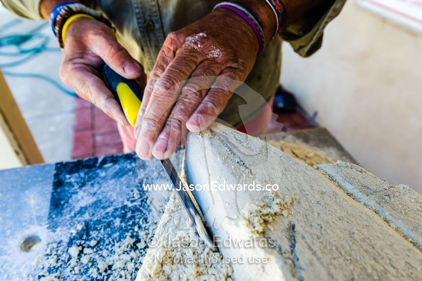 An artist helps a boy carve a shark into a block of sandstone during a school holiday program activity. Robe, Limestone Coast, South Australia, Australia.