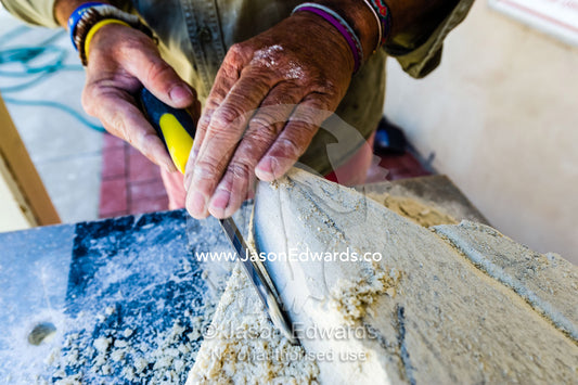 An artist helps a boy carve a shark into a block of sandstone during a school holiday program activity. Robe, Limestone Coast, South Australia, Australia.