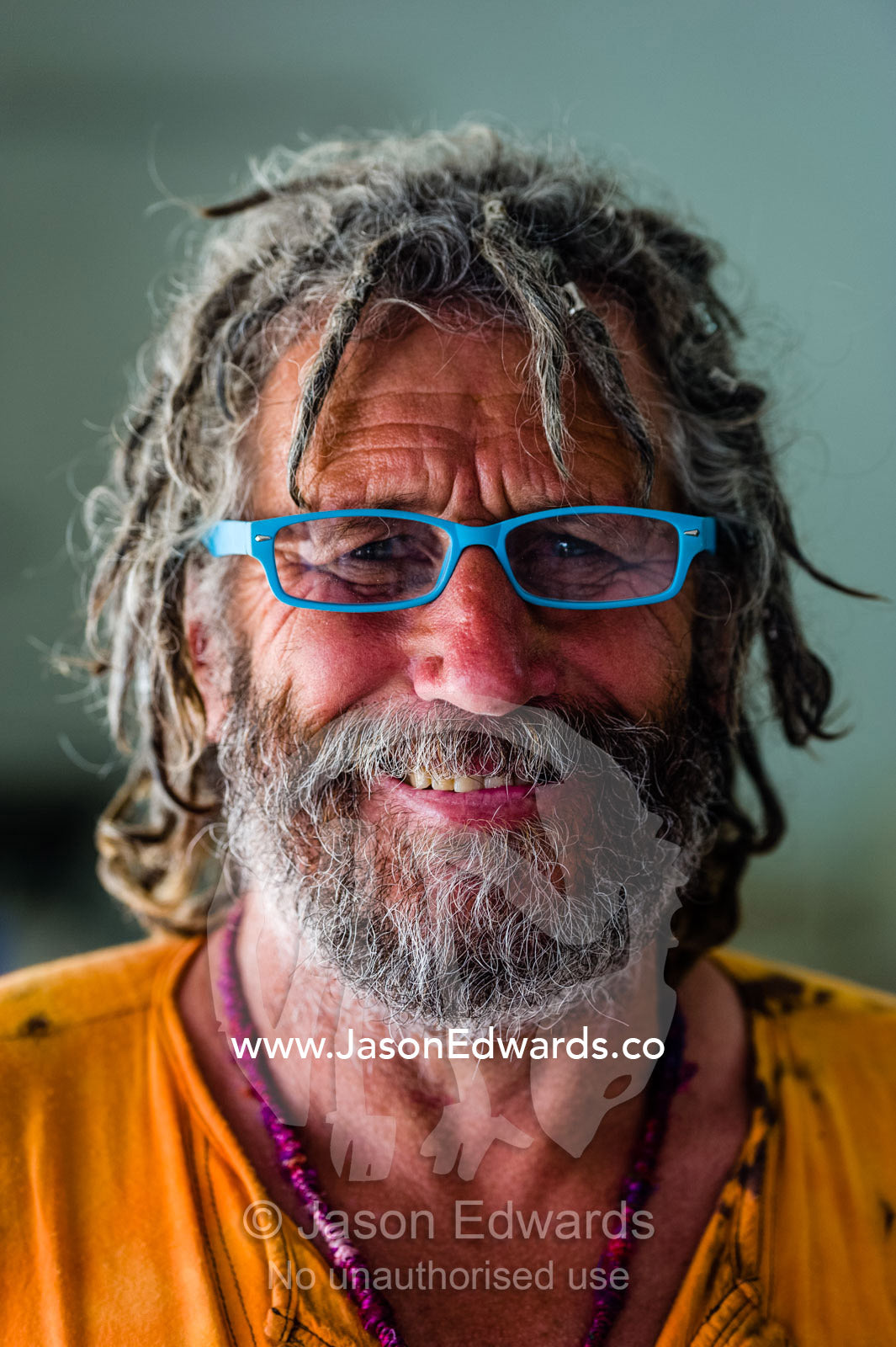 An artist with dreadlocks wearing funky blue reading glasses. Robe, Limestone Coast, South Australia, Australia.