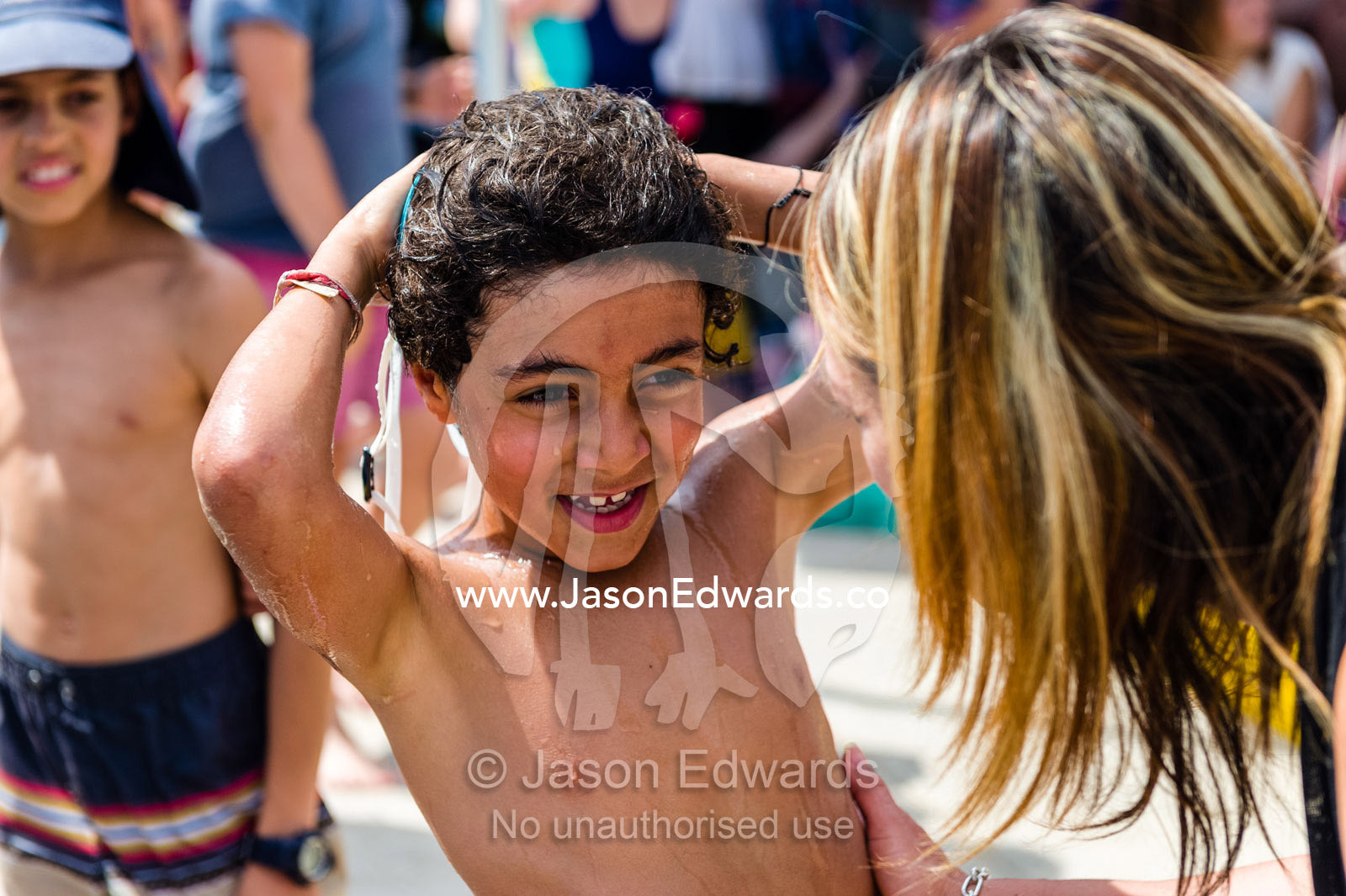 A mother congratulates her son at a school swimming carnival. Fitzroy, Melbourne, Victoria, Australia.