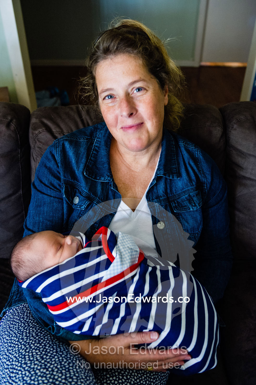 A woman nursing a new baby wrapped in a bundle. Cooranbong, New South Wales, Australia.
