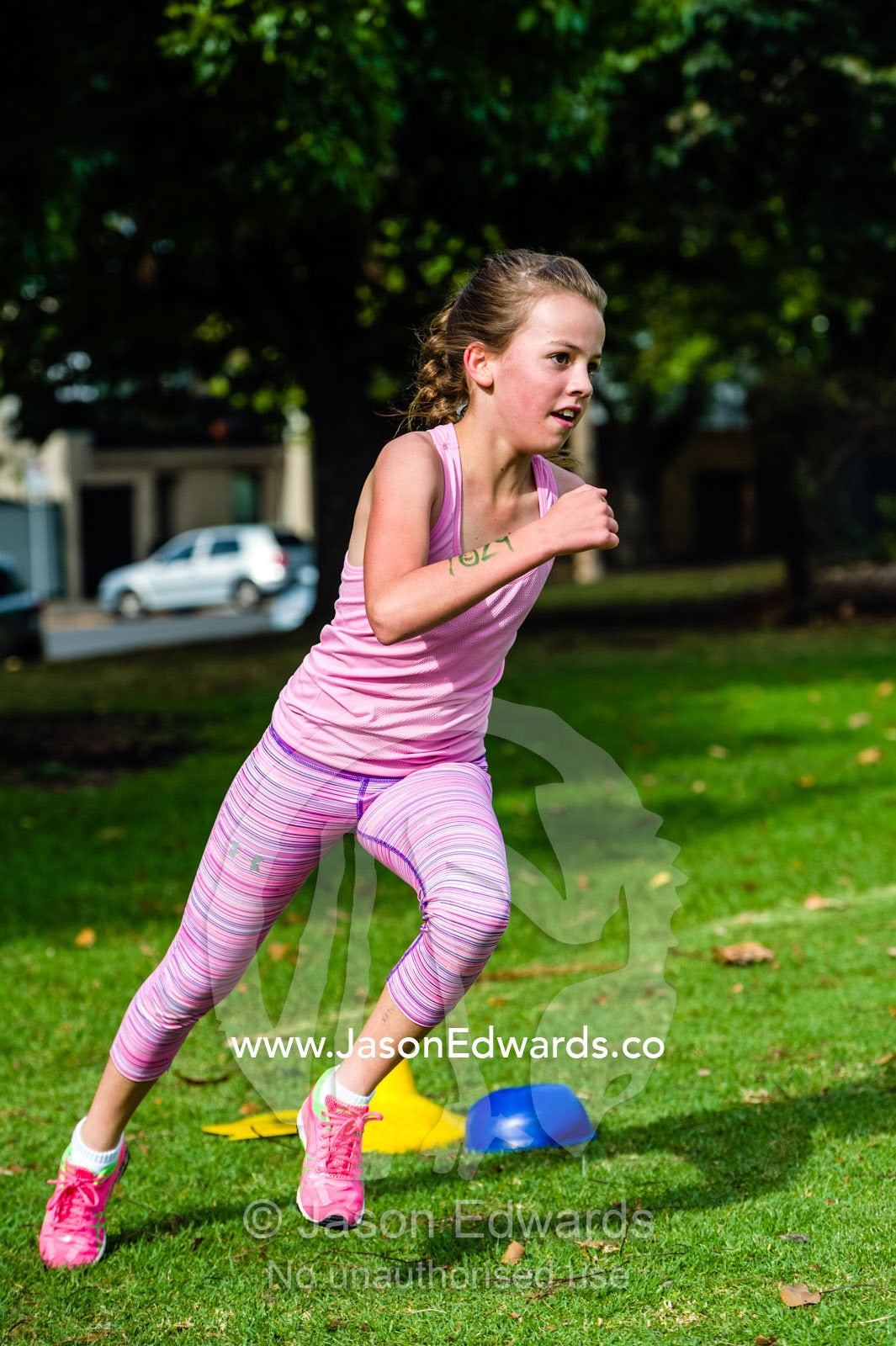 A girl running in an elementary school cross country race. Edinburgh Gardens, North Fitzroy, Melbourne, Victoria, Australia.