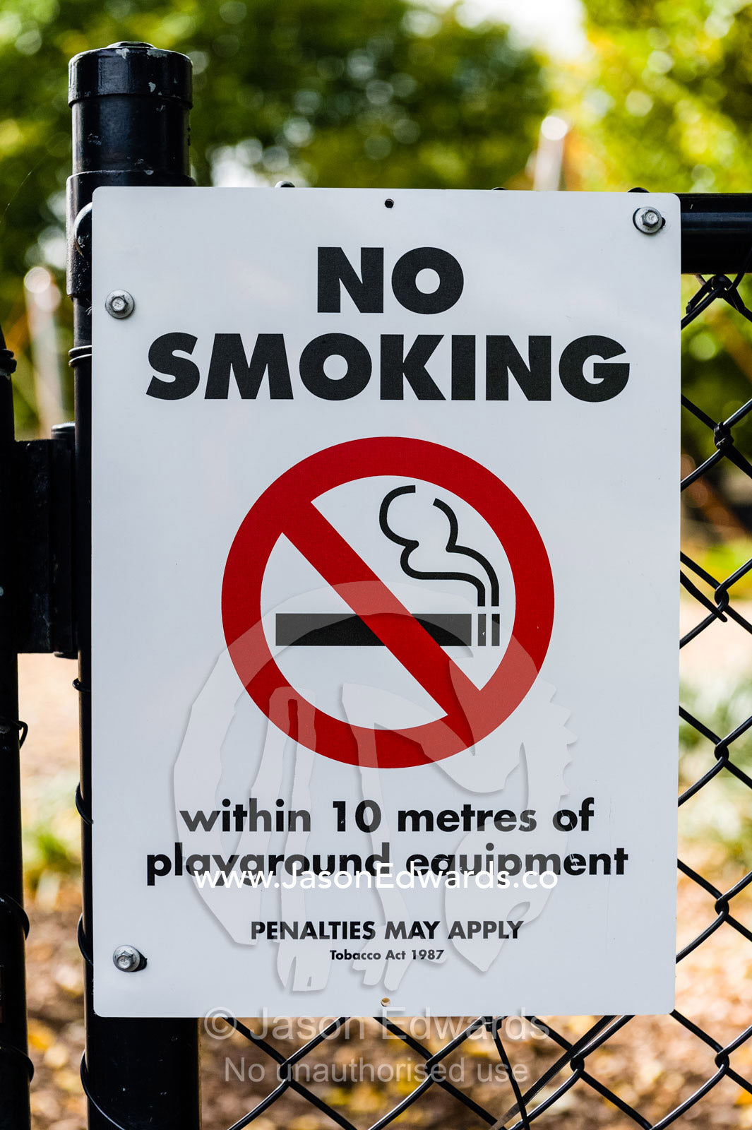 A no smoking sign on the fence of a children's playground. Edinburgh Gardens, North Fitzroy, Melbourne, Victoria, Australia.