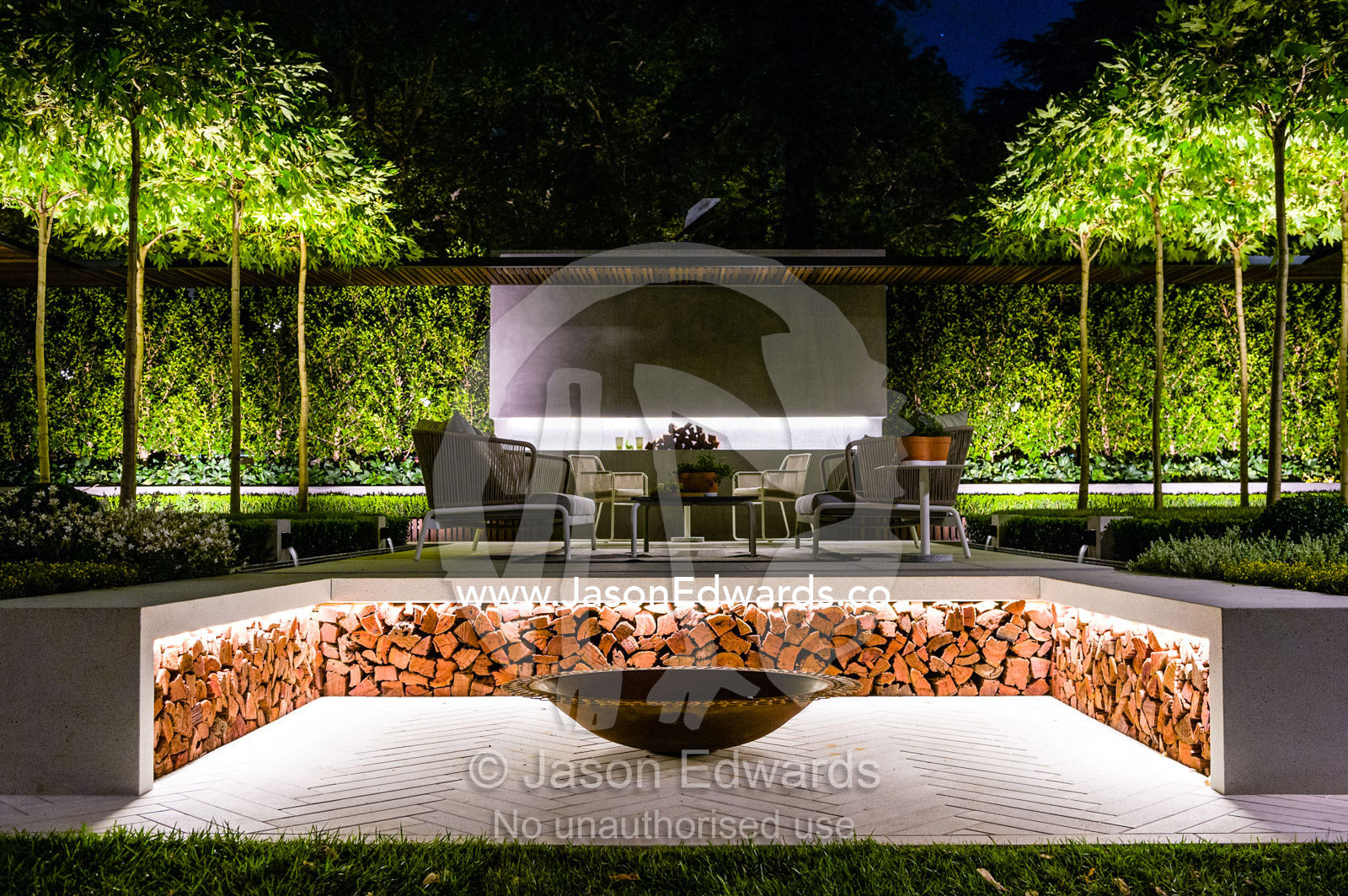 LED strip lighting illuminates a pile of fire logs in an outdoor garden patio at a garden show. Melbourne International Flower and Garden Show, Carlton Gardens, Carlton, Melbourne, Victoria, Australia.