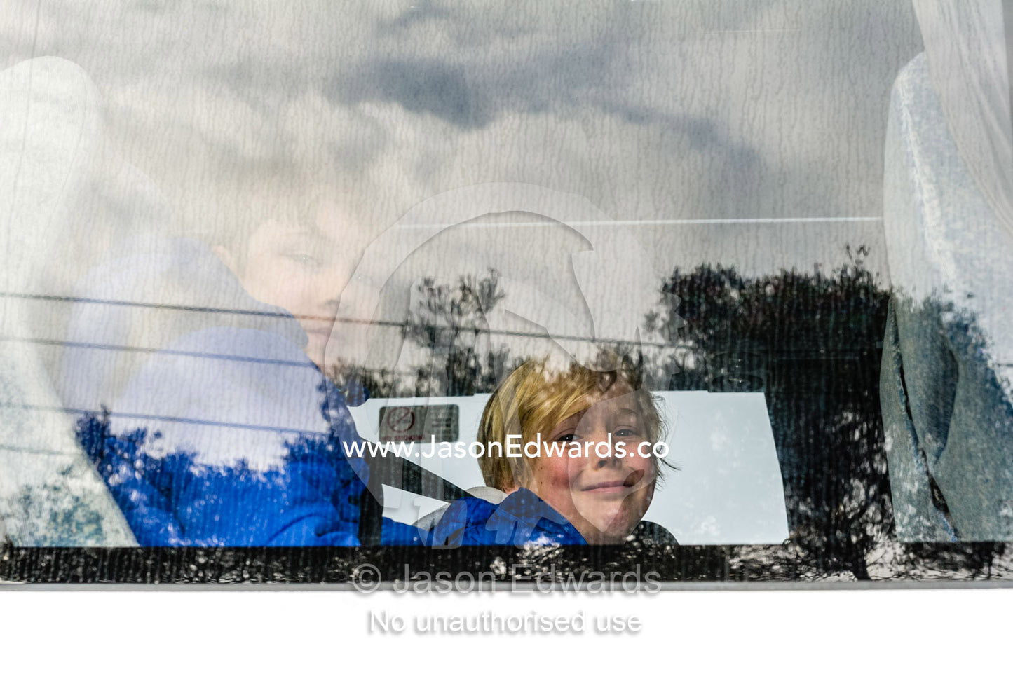 The sad face of a boy leaving his parents in a bus for school camp. Carlton North, Melbourne, Victoria, Australia.
