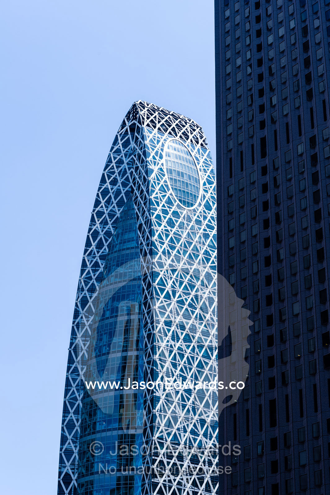 A wedge-shaped steel and glass office building in Tokyo. Shinjuku, Tokyo, Japan.