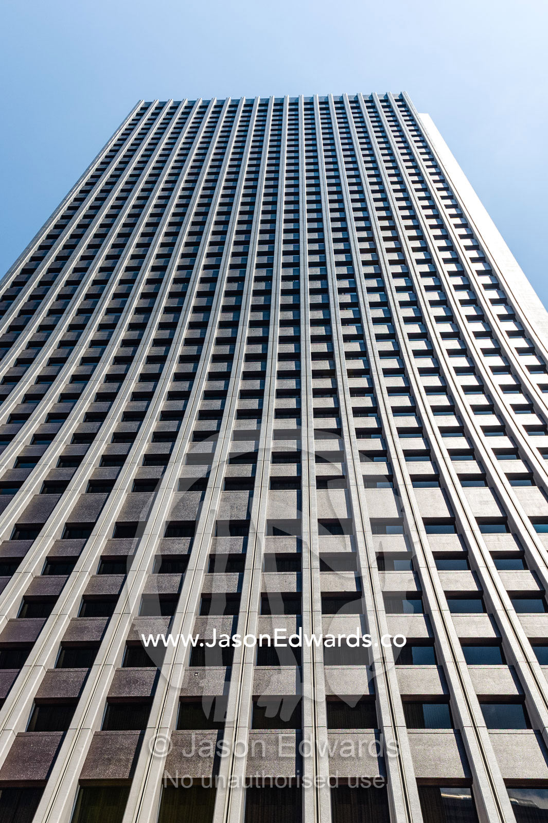 The linear steel and glass facade of an office building in Tokyo. Shinjuku, Tokyo, Japan.