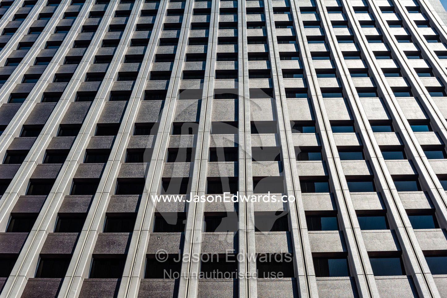 The linear steel and glass facade of an office building in Tokyo. Shinjuku, Tokyo, Japan.
