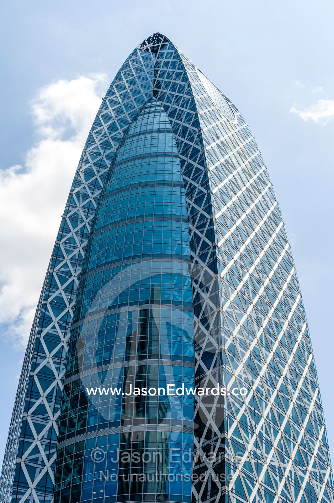 A wedge-shaped steel and glass office building in Tokyo. Shinjuku, Tokyo, Japan.