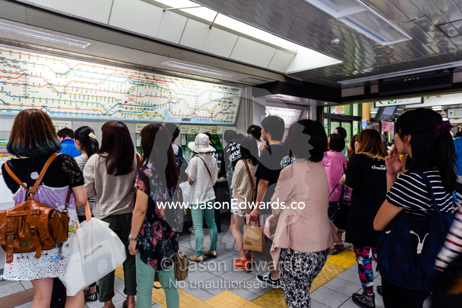 Commuters purchasing tickets at a railway station vending machine. Shinjuku Station, Shinjuku, Tokyo, Japan.