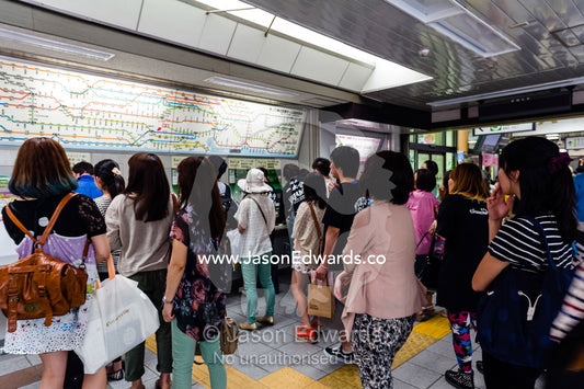 Commuters purchasing tickets at a railway station vending machine. Shinjuku Station, Shinjuku, Tokyo, Japan.