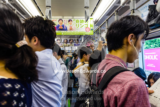Commuters standing in a crowded train carriage on the Tokyo railway. Shinjuku Station, Shinjuku, Tokyo, Japan.