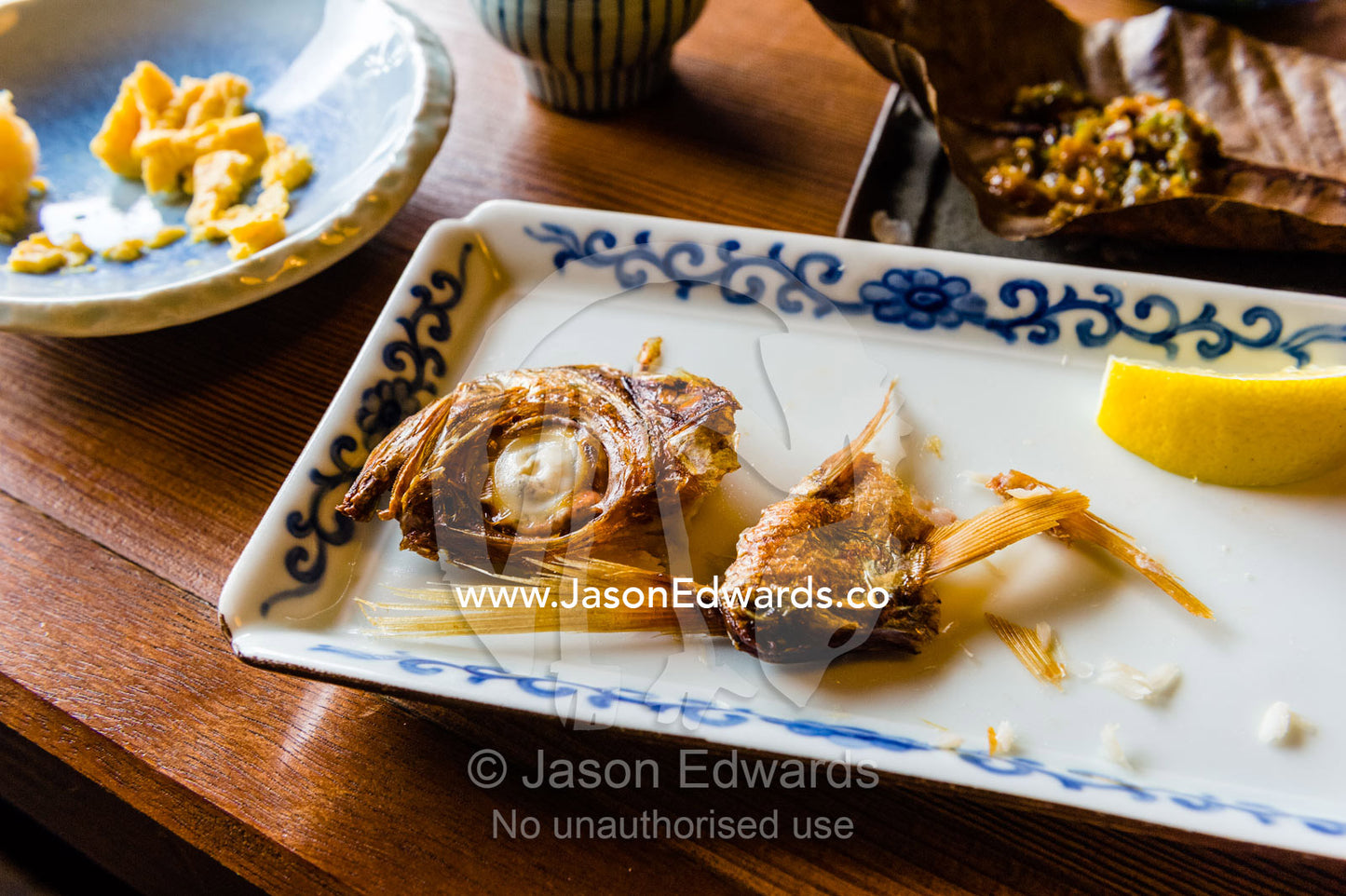 The fish head left-overs of a traditional Japanese breakfast called Choshoku served at a zataku centre table. Unryu Onsen, Izu Peninsula, Shizuoka Prefecture, Japan.