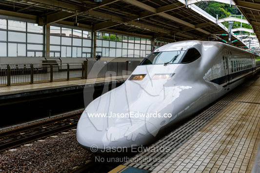 A Skinkansen or Japanese bullet Train at a railway platform. Okayama Station, Okayama, Okayama Prefecture, Japan.