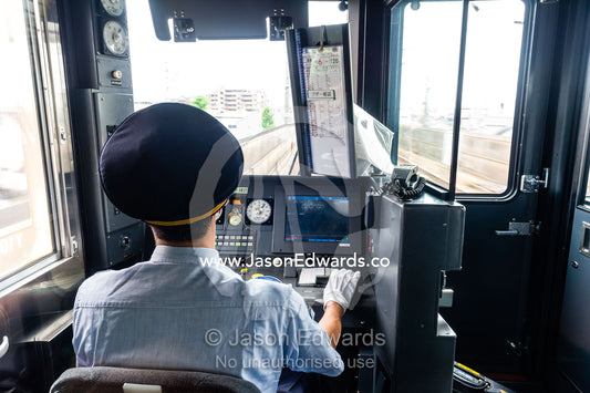 A train driver controls the speed of the locomotive from the cab. Nagoya, Chubu Region, Japan.