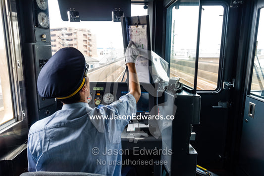 A train driver controls the speed of the locomotive from the cab. Nagoya, Chubu Region, Japan.