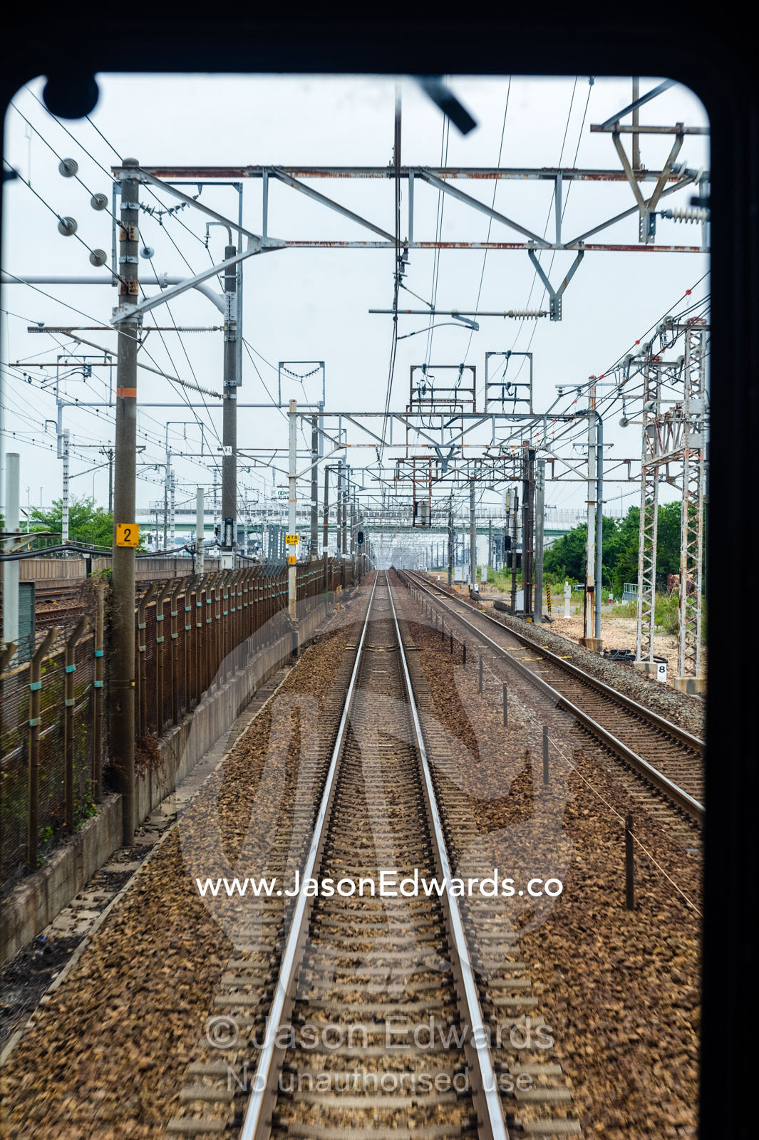The view down the railway tracks from the train driver compartment. Nagoya, Chubu Region, Japan.