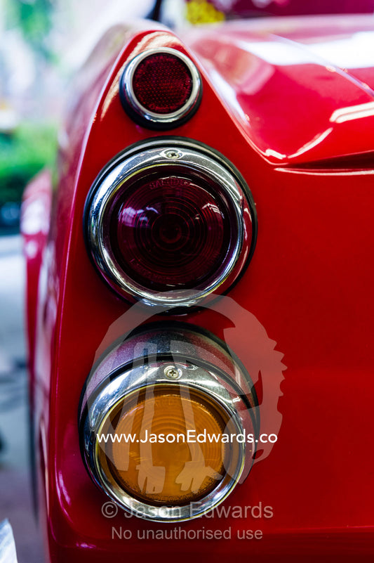The tail lights, indicators and stop lights on a classic bright red Datsun 2000 Sports car. Nagoya, Chubu Region, Japan.