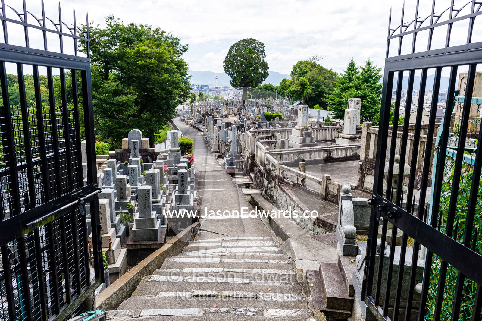 The open gates to a graveyard full of tombstones near a temple in Japan. Otani Honbyo Mausoleum, Kyoto, Japan.