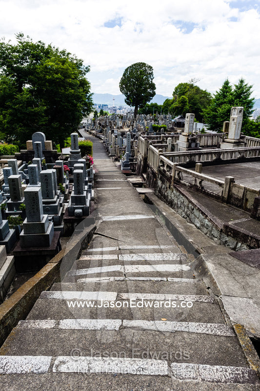 A path through a graveyard full of tombstones near a temple in Japan. Otani Honbyo Mausoleum, Kyoto, Japan.
