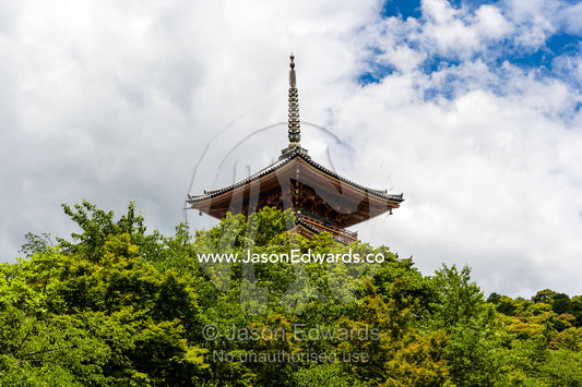 The hoju of a buddhist temple rising above the treetops of a garden. Kiyomizu-dera Temple, Higashiyama Ward, Kyoto, Kyoto Prefecture, Japan.