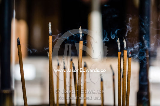 Incense sticks burning in a buddhist temple. Temple of the Golden Pavilion, Kinkaku-ji, Kyoto, Japan.