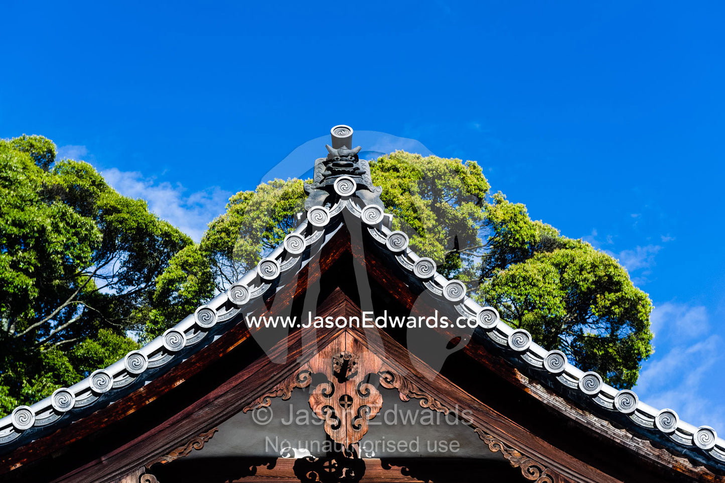 The ancient carved timber pitched roof of a buddhist temple. Temple of the Golden Pavilion, Kinkaku-ji, Kyoto, Japan.