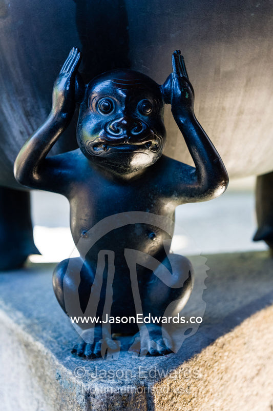The three monkeys of the Koshin faith represent not hearing, not seeing and not talking supporting a bowl sculpture. Yasaka Koshin-do Temple, Higashiyama, Kyoto, Japan.