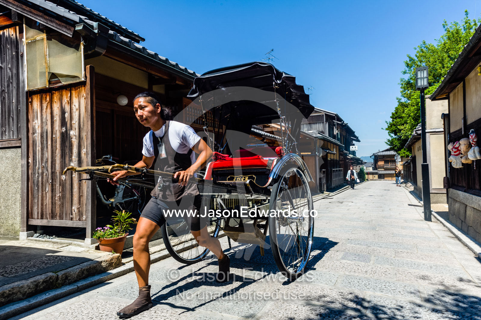 A rickshaw puller with powerful legs in a narrow street in Kyoto. Yasaka Pagoda, Hokanji Temple, Higashiyama, Kyoto, Japan.