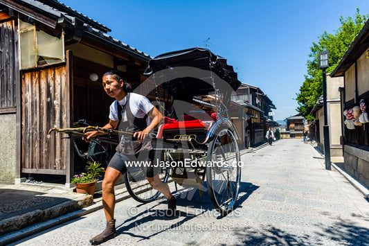 A rickshaw puller with powerful legs in a narrow street in Kyoto. Yasaka Pagoda, Hokanji Temple, Higashiyama, Kyoto, Japan.