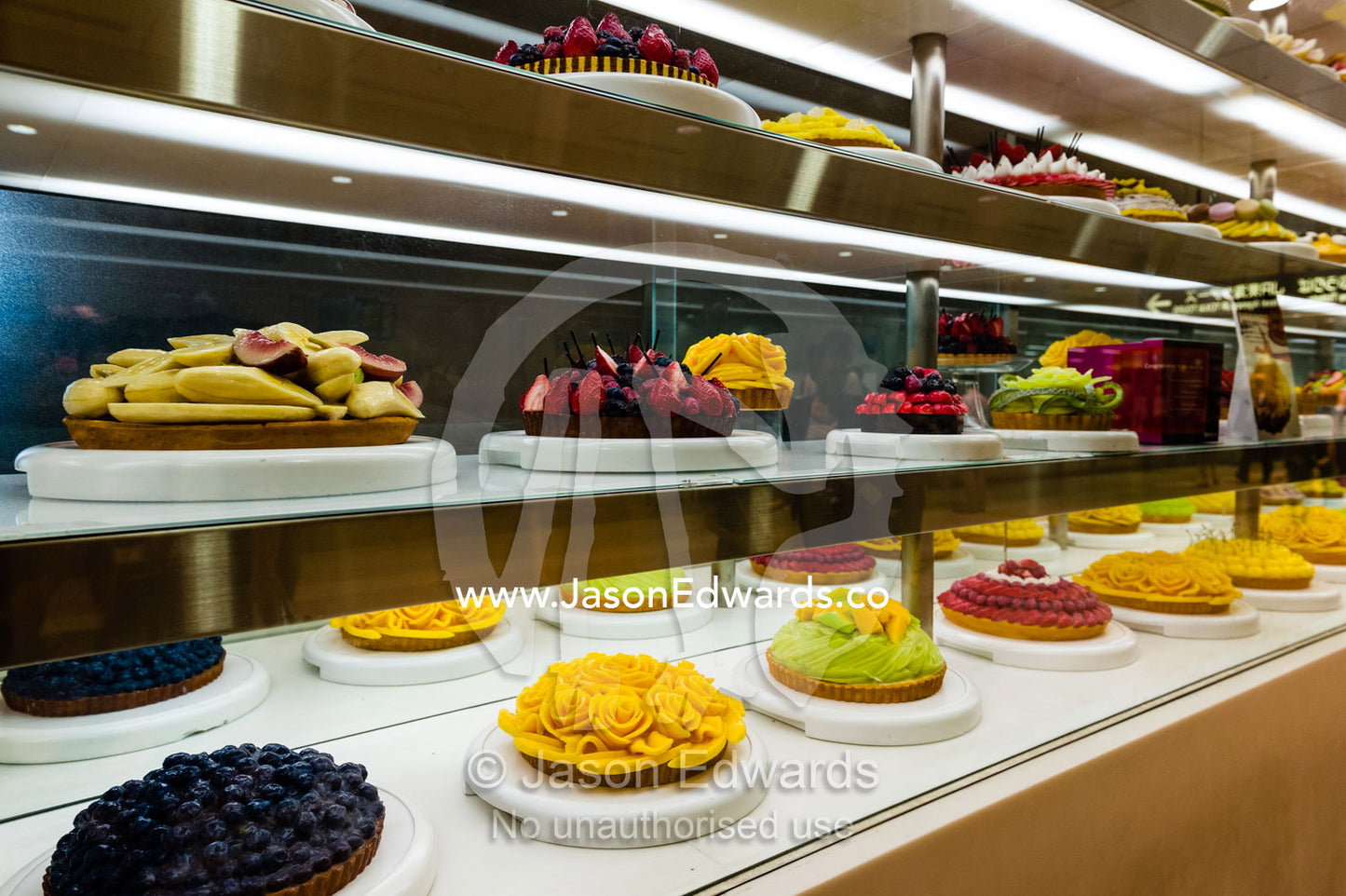 A glass display case with decorated cakes in a railway station in Japan. Hiroshima, Honshu Island, Japan.