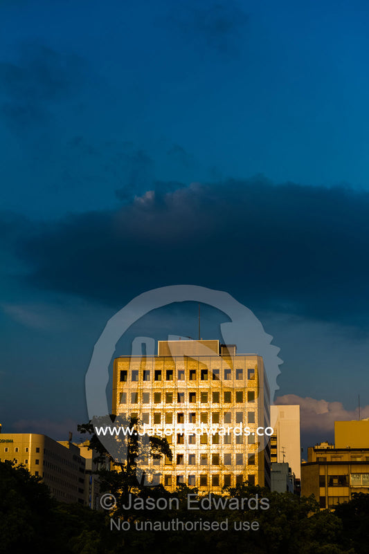 Sunset turns the facade of an office building golden near the Atomic Bomb Dome. Hiroshima, Honshu Island, Japan.