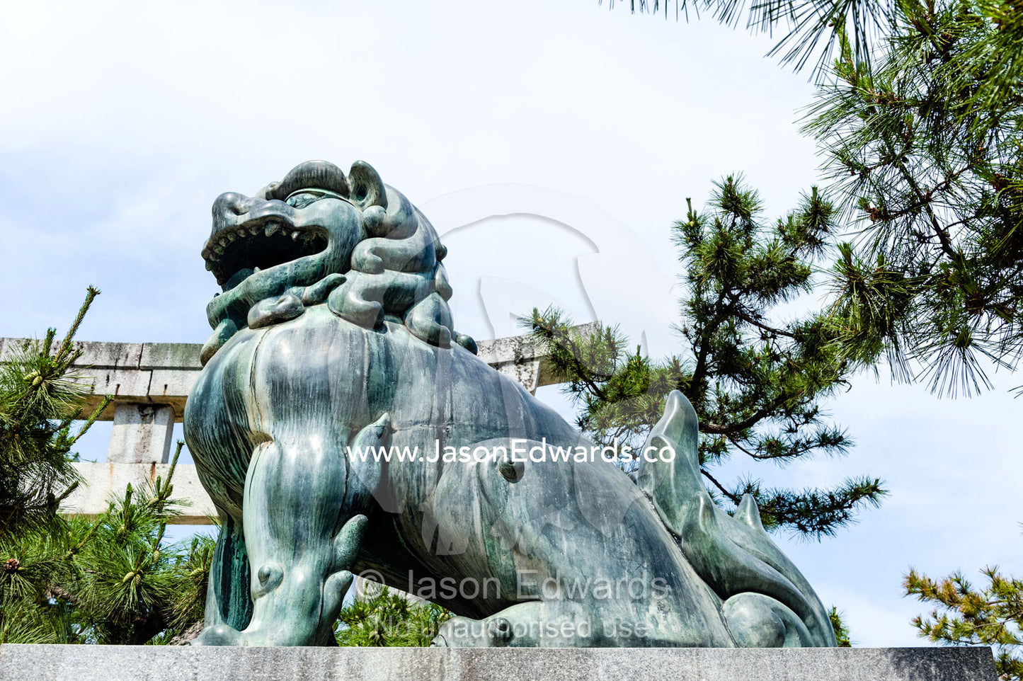 A Komainu lion statue guarding a shrine from evil sprits. Itsukushima Shrine, Miyajima, Itsukushima Island, Inland Sea of Japan, Hiroshima Bay, Japan.