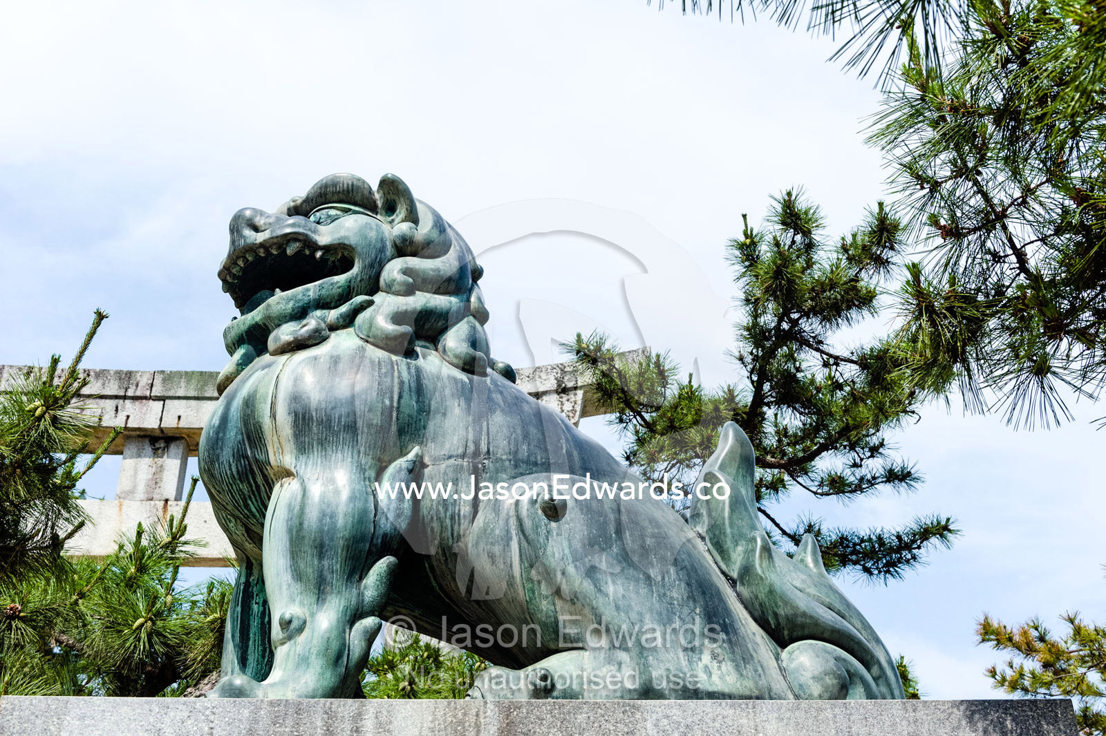 A Komainu lion statue guarding a shrine from evil sprits. Itsukushima Shrine, Miyajima, Itsukushima Island, Inland Sea of Japan, Hiroshima Bay, Japan.