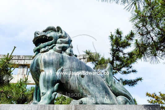 A Komainu lion statue guarding a shrine from evil sprits. Itsukushima Shrine, Miyajima, Itsukushima Island, Inland Sea of Japan, Hiroshima Bay, Japan.