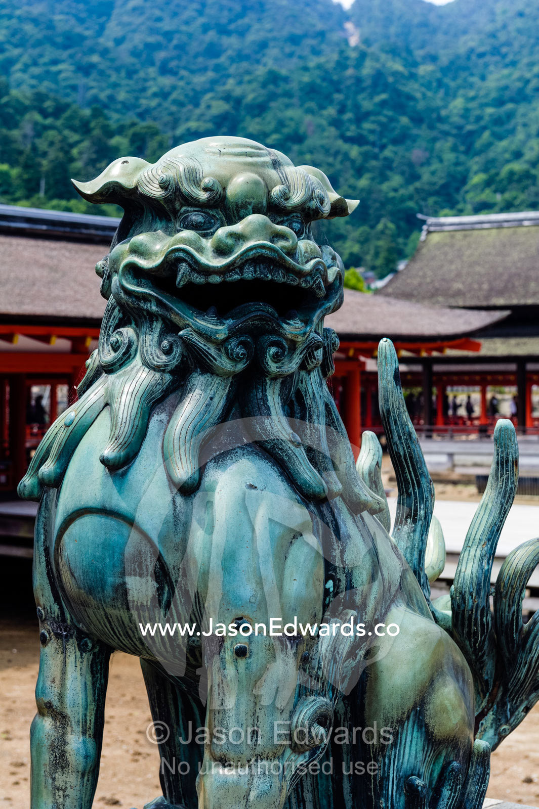 A Komainu lion statue guarding a shrine from evil sprits. Itsukushima Shrine, Miyajima, Itsukushima Island, Inland Sea of Japan, Hiroshima Bay, Japan.