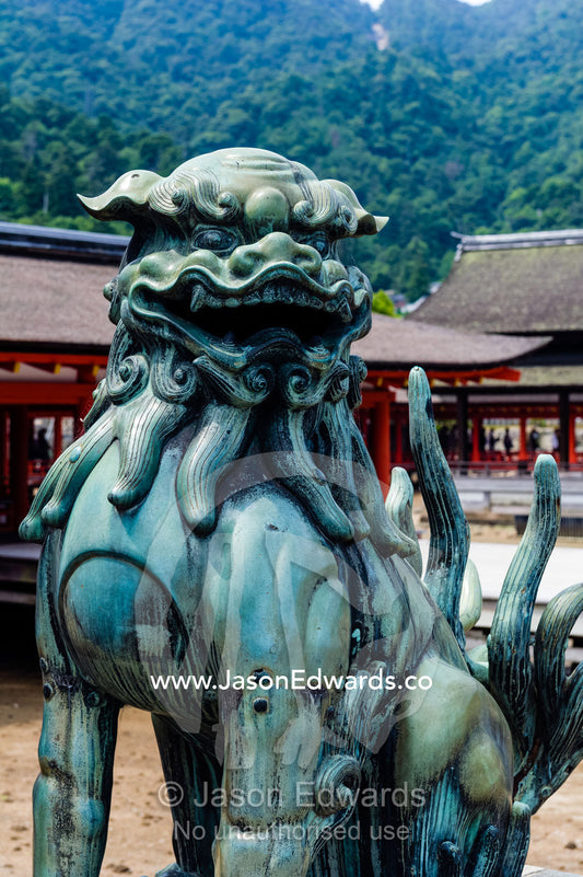 A Komainu lion statue guarding a shrine from evil sprits. Itsukushima Shrine, Miyajima, Itsukushima Island, Inland Sea of Japan, Hiroshima Bay, Japan.