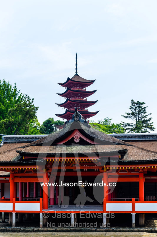 A tiered pagoda rises over the Itsukushima Shrine. Itsukushima Shrine, Miyajima, Itsukushima Island, Inland Sea of Japan, Hiroshima Bay, Japan.