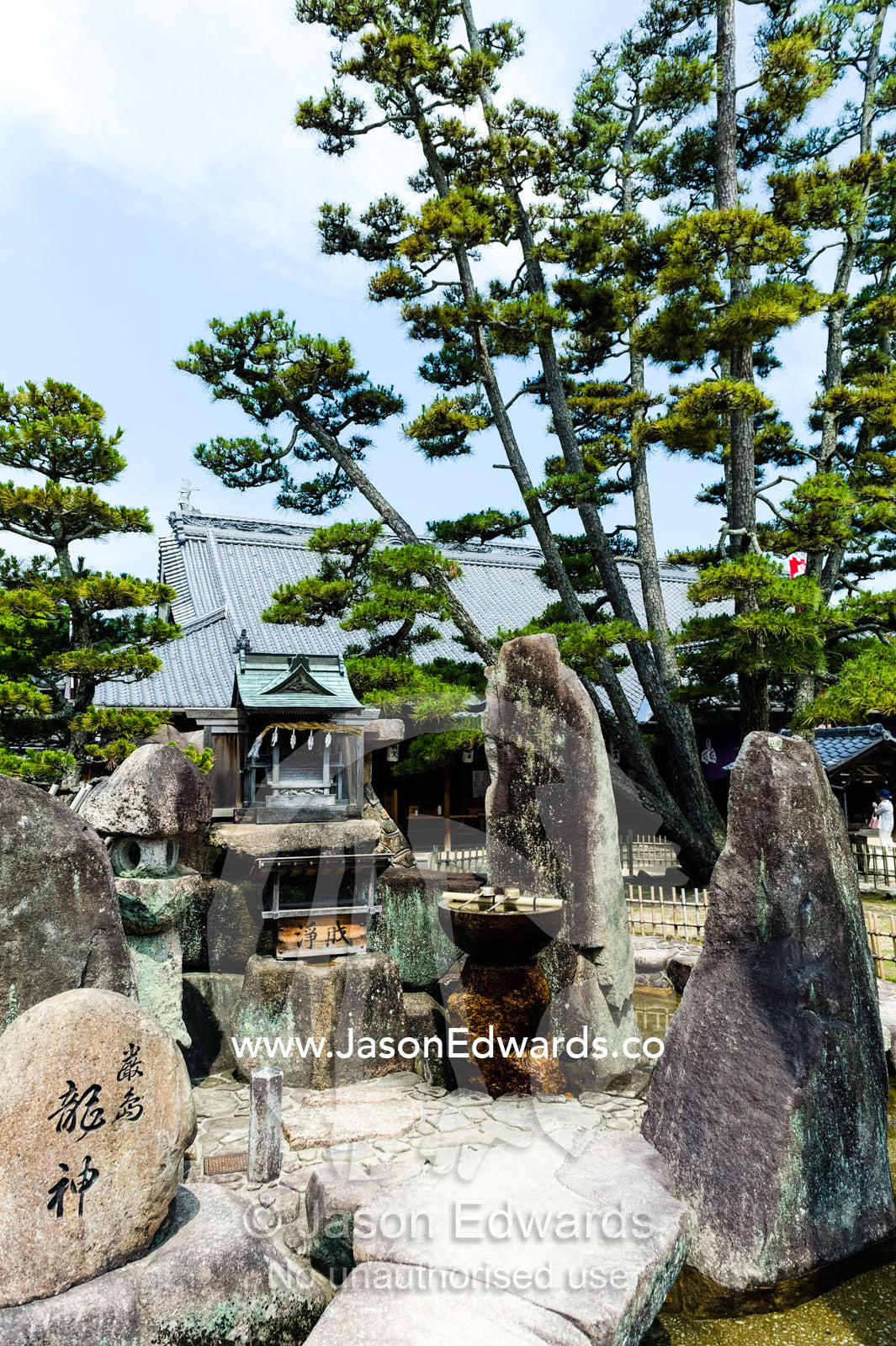 An ancient stone and sculpture garden near a temple. Itsukushima Shrine, Miyajima, Itsukushima Island, Inland Sea of Japan, Hiroshima Bay, Japan.