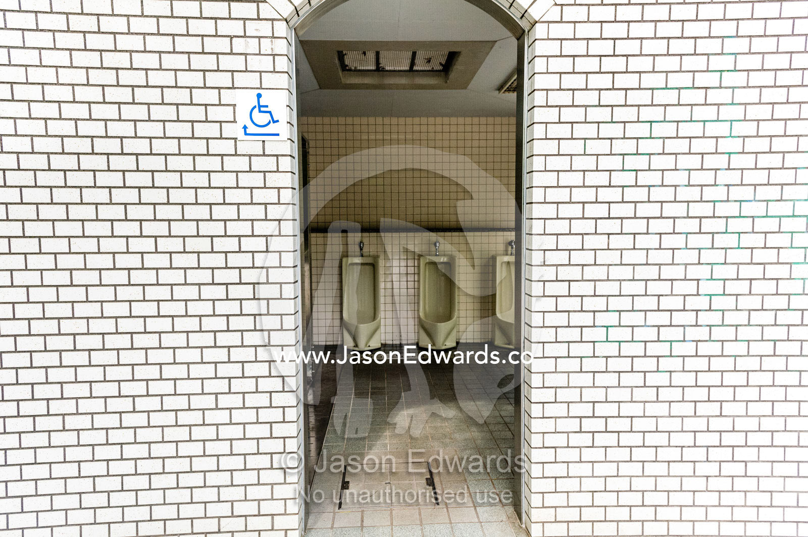 The open doorway to a public urinal in Japan. Hiroshima Peace Memorial Park, Hiroshima, Honshu Island, Japan.