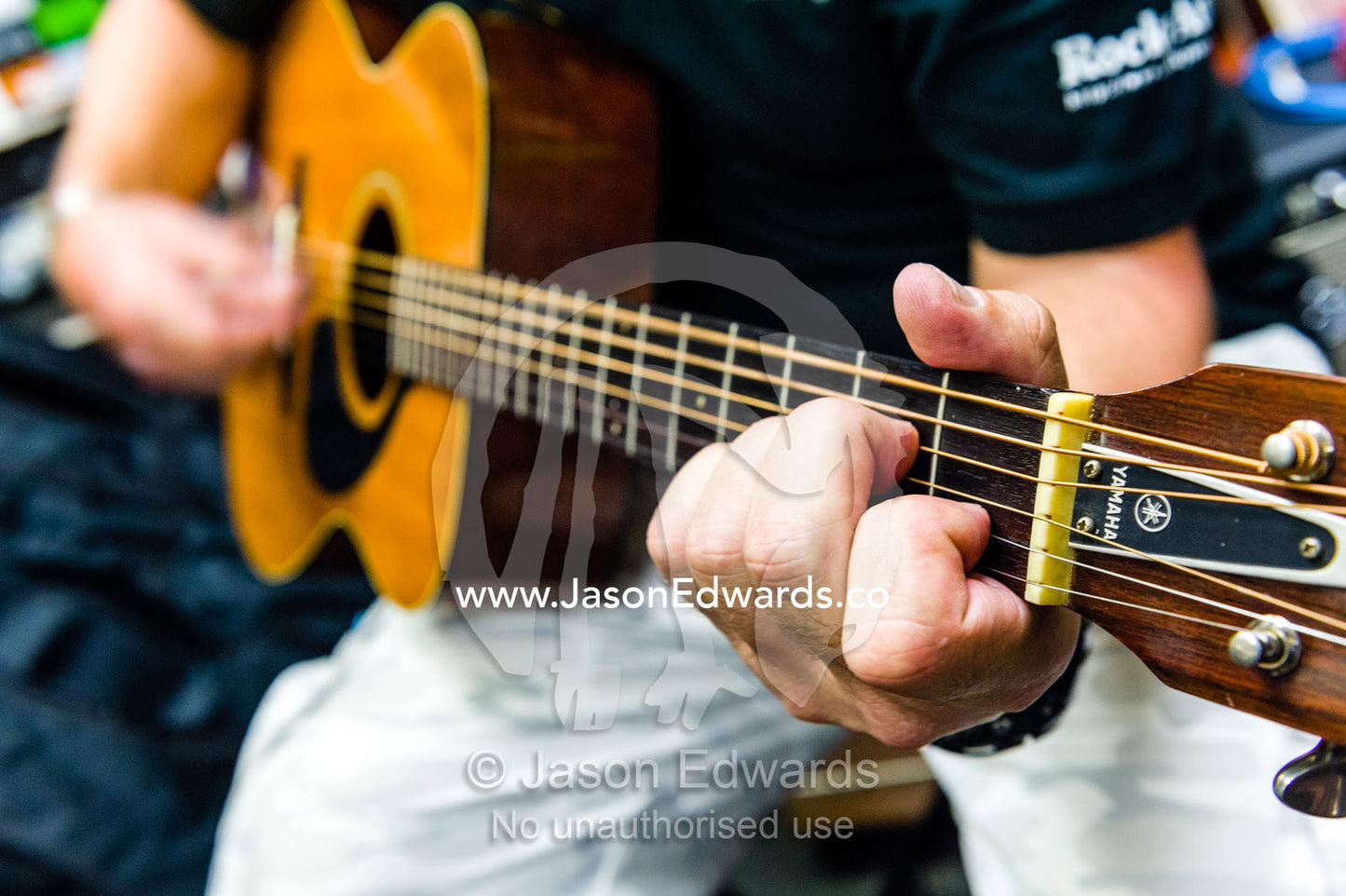 A man tests a guitar to purchase in a Japanese music store. Hiroshima, Honshu Island, Japan.