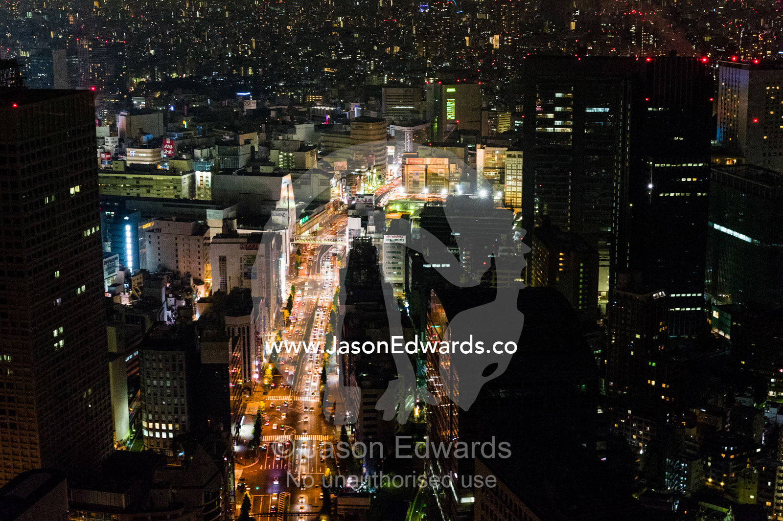Traffic congestion on the streets beneath the Tokyo city skyline at night. Park Hyatt, Tokyo, Japan.