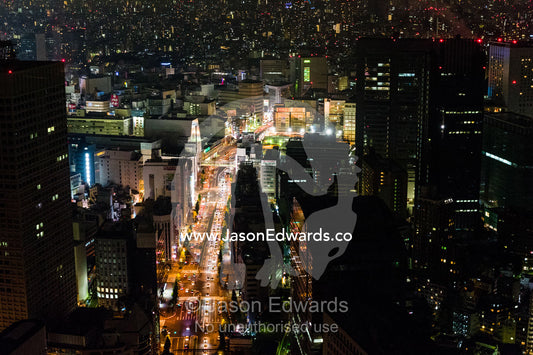 Traffic congestion on the streets beneath the Tokyo city skyline at night. Park Hyatt, Tokyo, Japan.