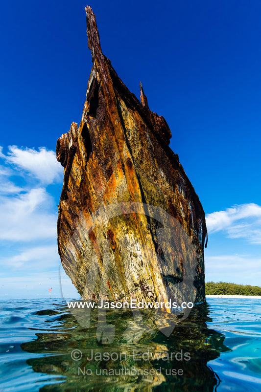 The rusting shipwreck of the HMAS Protector a large flat-iron gunboat trapped on a coral reef. Wreck Beach, Heron Island, Great Barrier Reef, Queensland, Australia.