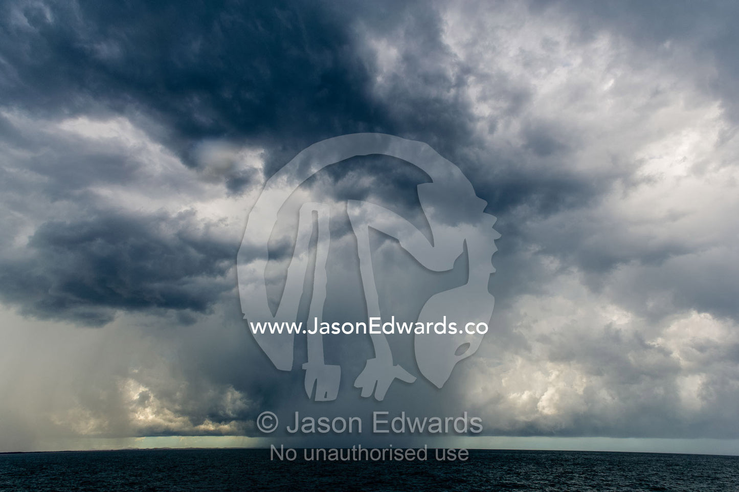 A menacing tropical rainstorm darkens the ocean and the sky. Gladstone, Queensland, Australia.