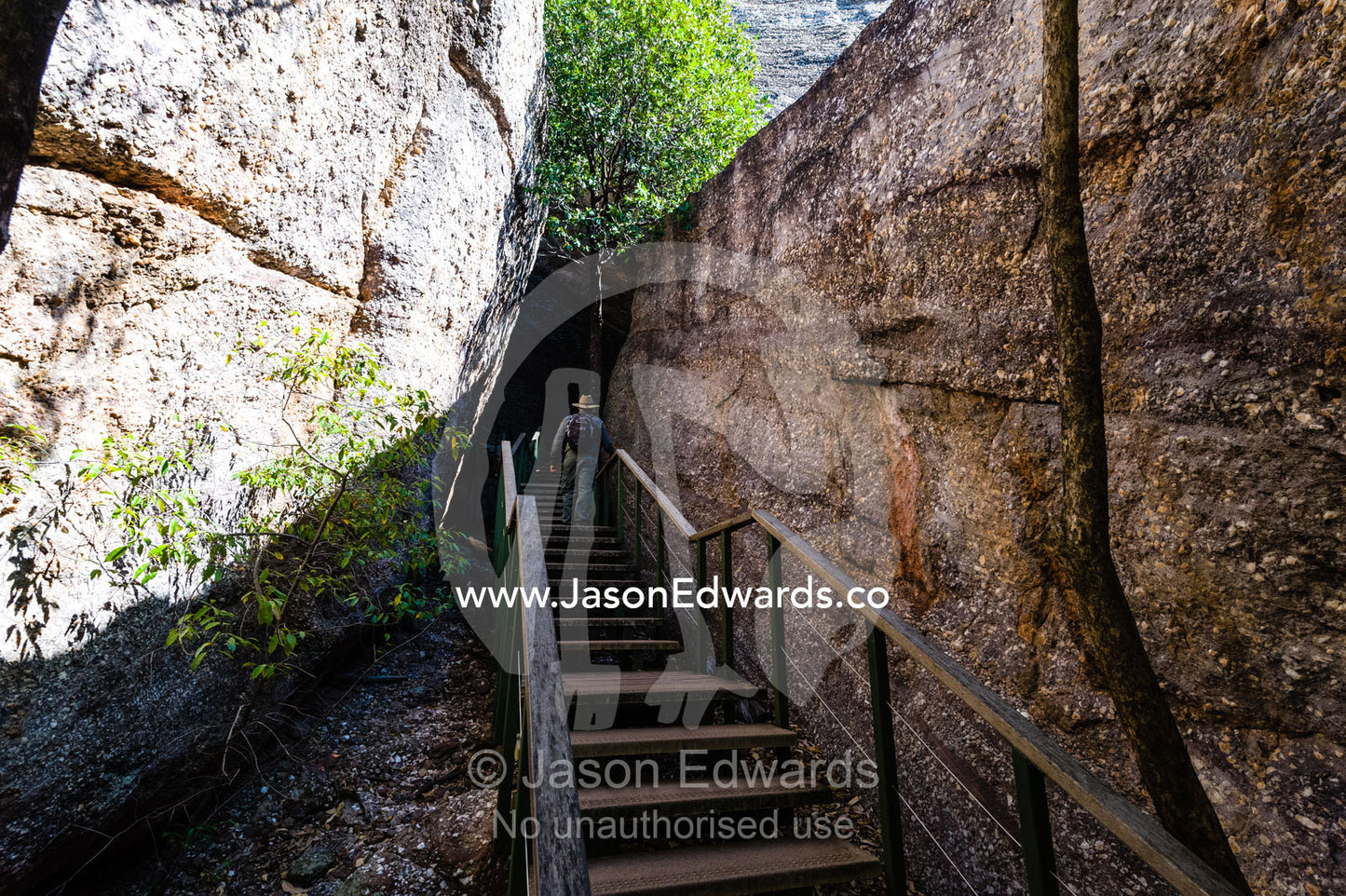 A timber staircase leads between boulders in a canyon to aboriginal rock painting art galleries. Burrunggui, Nourlangie Rock, Arnhem Land, Kakadu National Park, Northern Territory, Australia.
